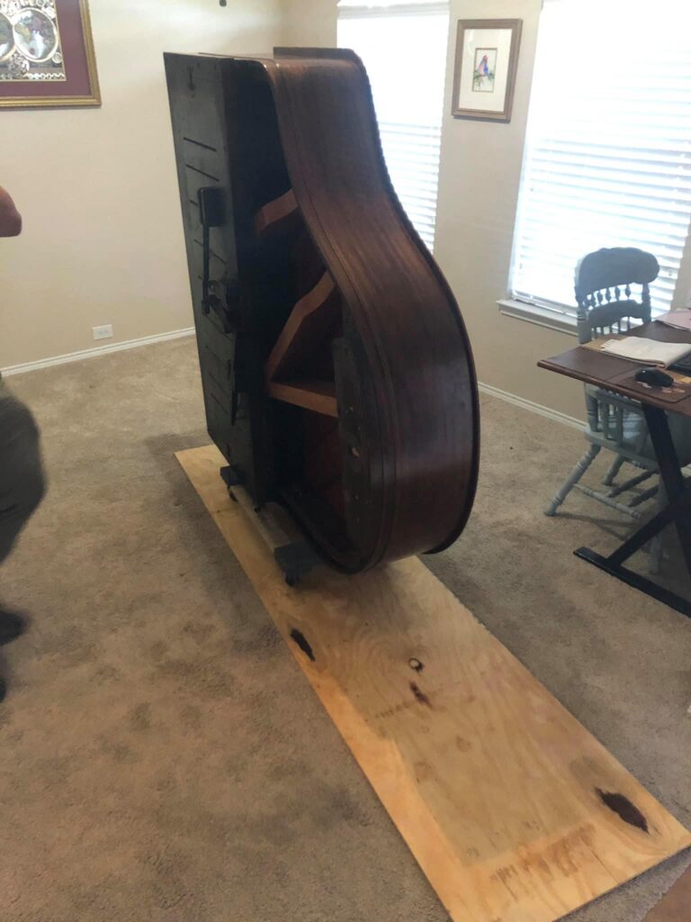 putting a piano on its side to then haul it away