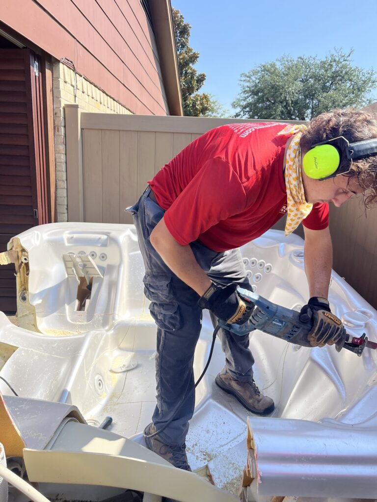 jm junk crew member cutting hot tub for removal in lake highlands